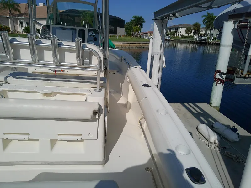 Slide: The Image of 2004 Trophy 2503 Center Console boat docked by a serene waterfront. - 16