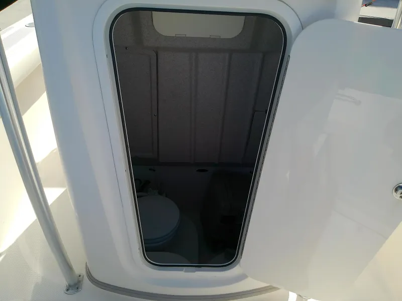 Slide: The Image of Open hatch on 2004 Trophy 2503 Center Console boat, revealing interior storage space. - 44