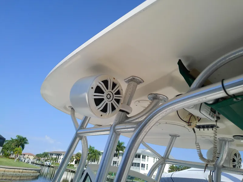 Slide: The Image of 2004 Trophy 2503 Center Console boat with speaker and canopy, docked near waterfront homes. - 48