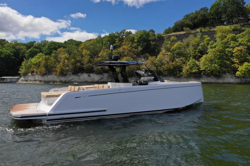Slide: The Image of 2024 Pardo Yachts P43 cruising on a scenic lake with lush green shoreline. - 3