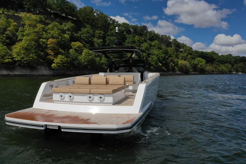 Slide: The Image of 2024 Pardo Yachts P43 cruising on a scenic lake with lush green shoreline. - 5