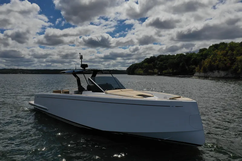 The Image of 2024 Pardo Yachts P43 cruising on a scenic lake under a cloudy sky. - 1