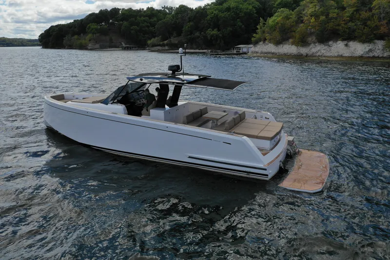 Slide: The Image of 2024 Pardo Yachts P43 cruising on a scenic lake with lush green shoreline. - 16