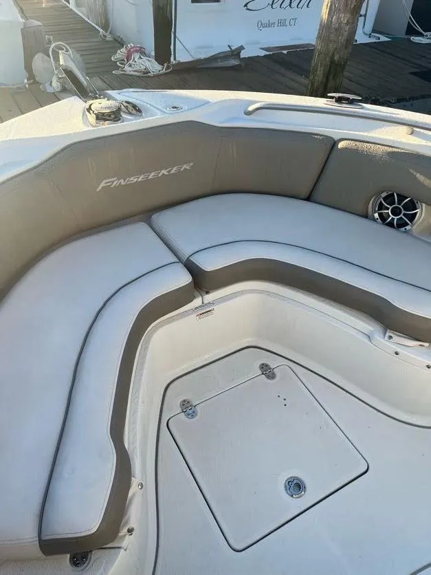 Slide: The Image of 2023 Crownline 220 CC Finseeker boat interior with cushioned seating and speaker. - 10