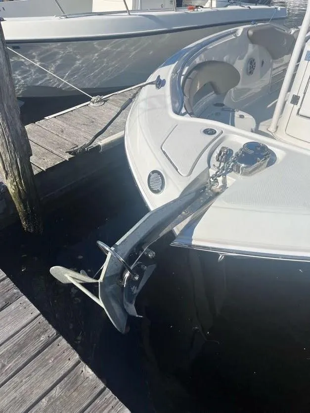 Slide: The Image of 2023 Crownline 220 CC Finseeker boat docked with anchor visible. - 11