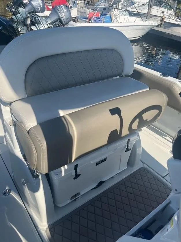 Slide: The Image of 2023 Crownline 220 CC Finseeker boat interior with cushioned seating and storage. - 12
