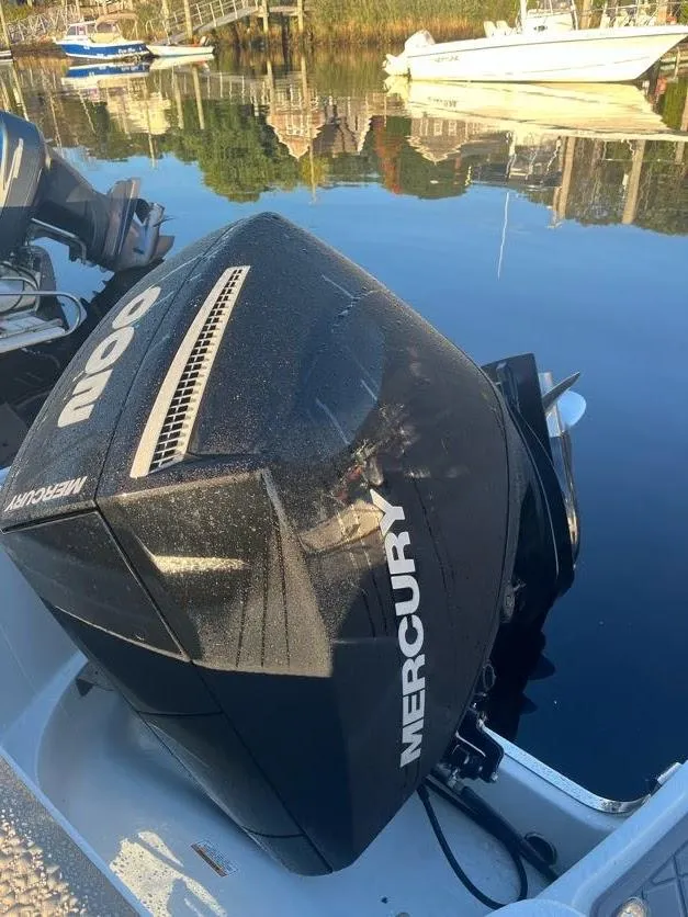 Slide: The Image of 2023 Crownline 220 CC Finseeker with Mercury outboard engine on calm water. - 14