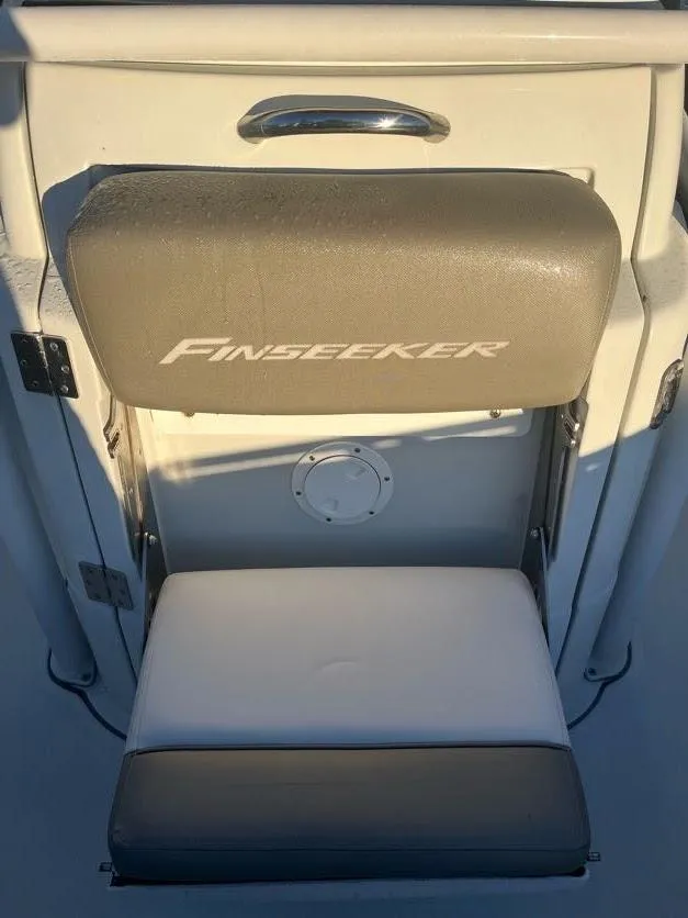 Slide: The Image of 2023 Crownline 220 CC Finseeker boat seat with logo, beige and white upholstery. - 9