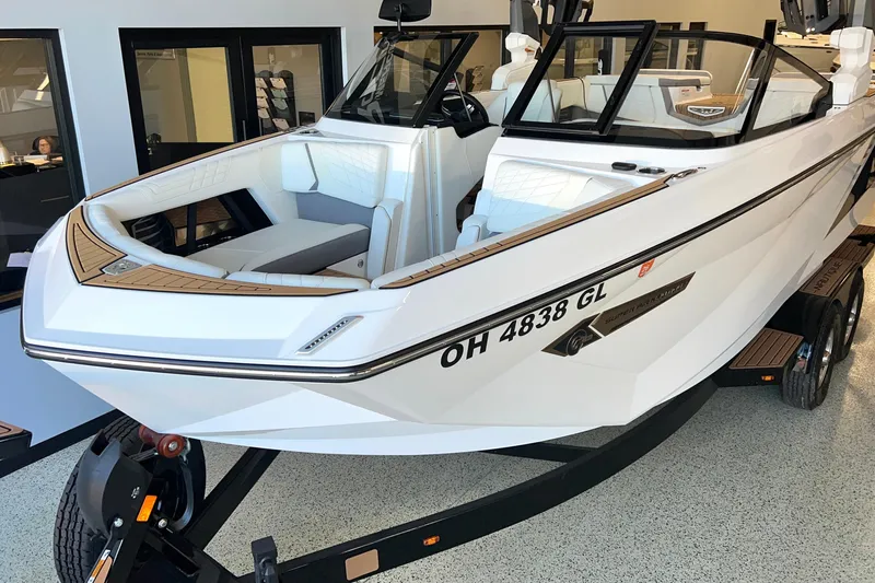 Slide: The Image of 2023 Nautique Super Air G23 boat on trailer, white exterior, displayed indoors. - 1