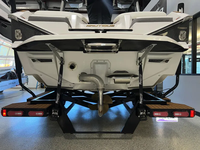 Slide: The Image of 2023 Nautique Super Air G23 boat rear view in showroom setting. - 12