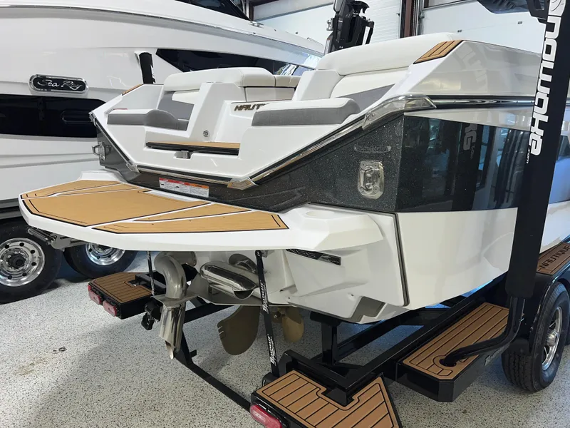 Slide: The Image of 2023 Nautique Super Air G23 boat, rear view in showroom, showcasing sleek design and features. - 13