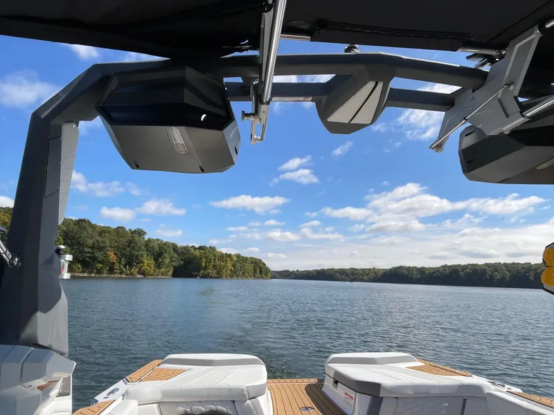 Slide: The Image of 2023 Nautique Super Air G23 on a serene lake with clear skies. - 57