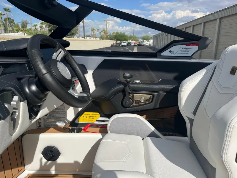 Slide: The Image of 2023 Nautique Super Air G23 boat interior with sleek steering and white seating. - 61