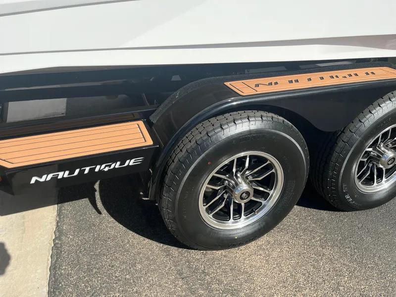 Slide: The Image of 2023 Nautique Super Air G23 trailer with dual wheels and branded detailing. - 63