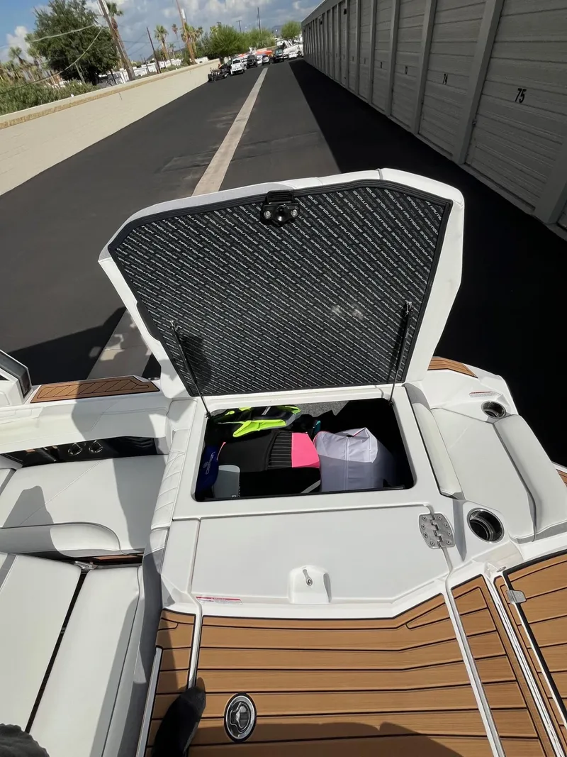 Slide: The Image of 2023 Nautique Super Air G23 boat storage compartment open, showing interior contents. - 74