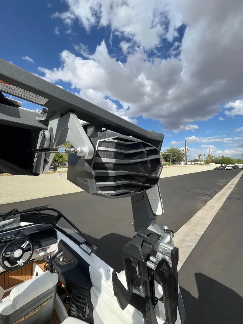 Slide: The Image of 2023 Nautique Super Air G23 boat with advanced speaker system under a blue sky. - 79