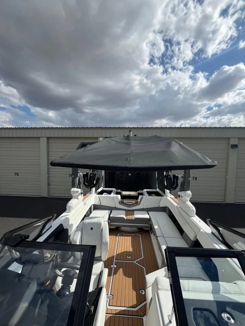 Slide: The Image of 2023 Nautique Super Air G23 boat with sleek design, docked under cloudy sky. - 81