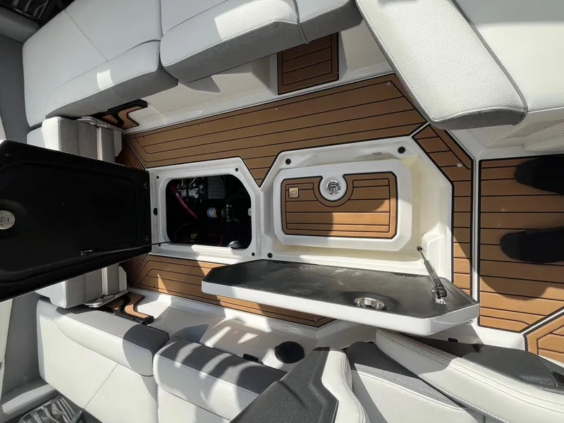 Slide: The Image of 2023 Nautique Super Air G23 interior with open storage compartments and teak flooring. - 87
