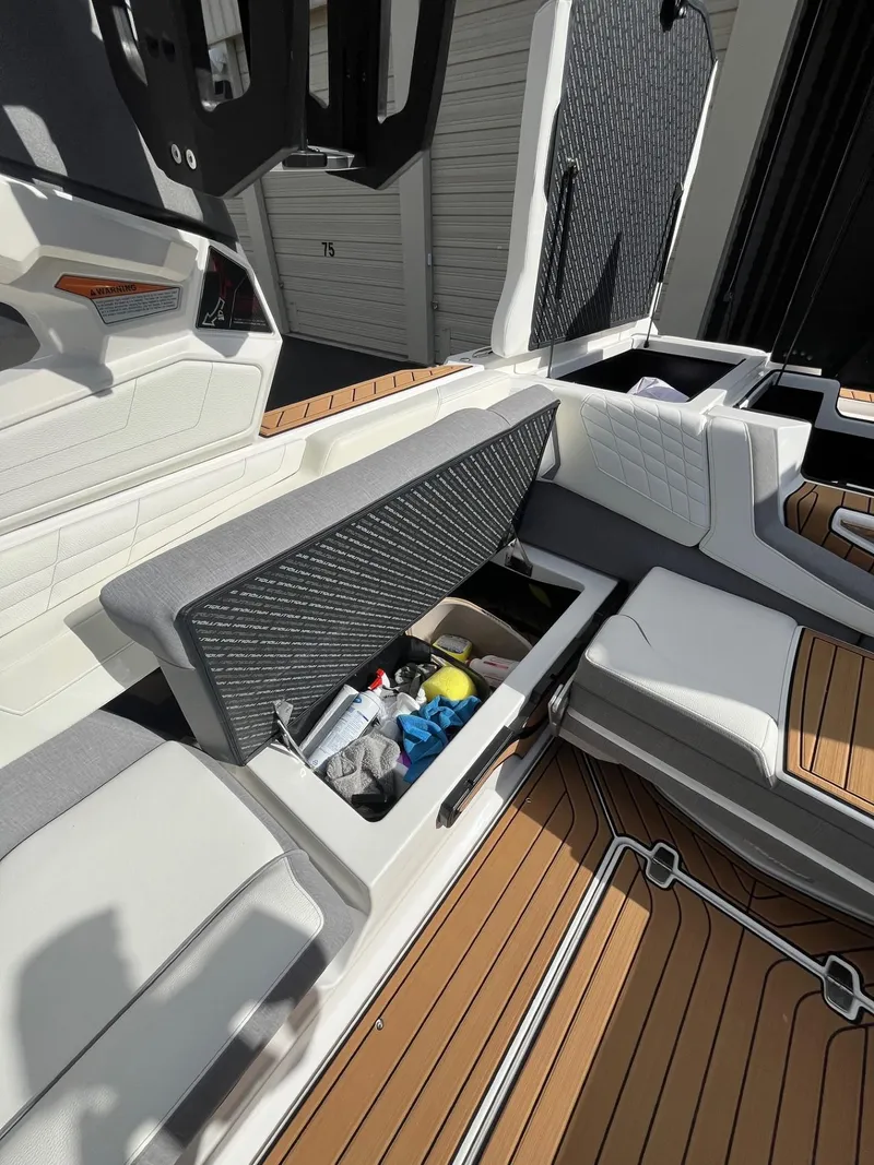 Slide: The Image of 2023 Nautique Super Air G23 boat interior with open storage compartment. - 89