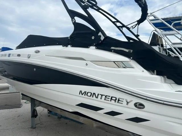Slide: The Image of 2018 Monterey M45 boat with sleek black and white design on a trailer. - 2