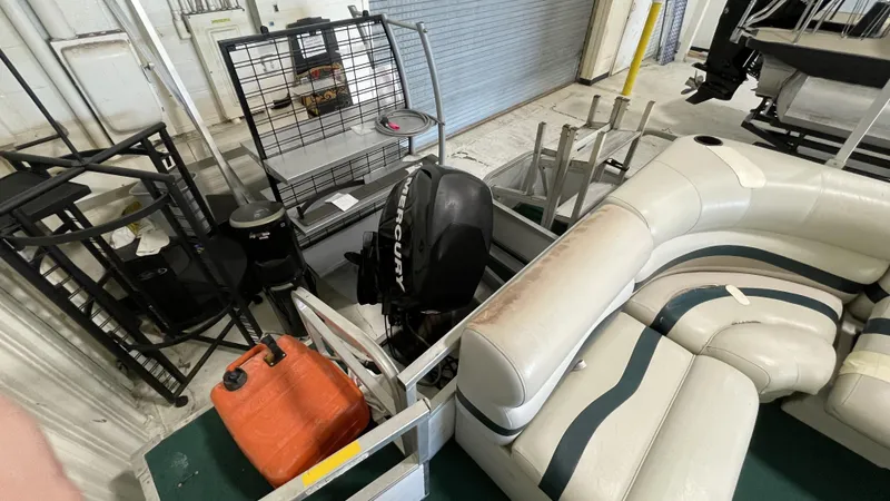 Slide: The Image of 1991 Sweetwater 2350 boat interior with Mercury engine and seating. - 11