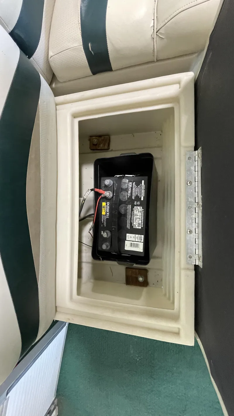 Slide: The Image of Battery compartment in 1991 Sweetwater 2350 boat, featuring a securely installed marine battery. - 4