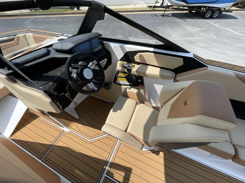 Slide: The Image of 2025 Nautique Super Air S S23 boat interior with modern dashboard and luxurious seating. - 12