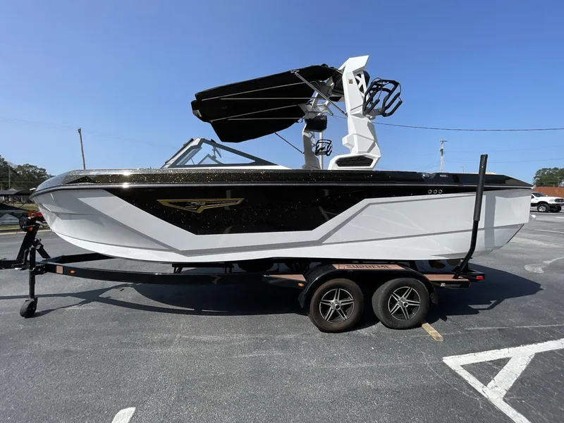 Slide: The Image of 2025 Nautique Super Air S S23 boat on trailer, black and white design. - 14