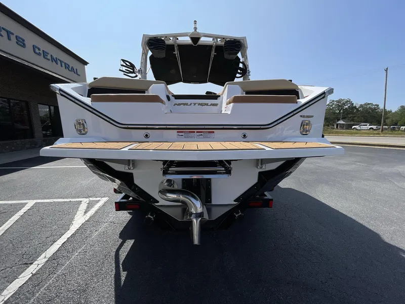 Slide: The Image of 2025 Nautique Super Air S S23 boat rear view in parking lot. - 16