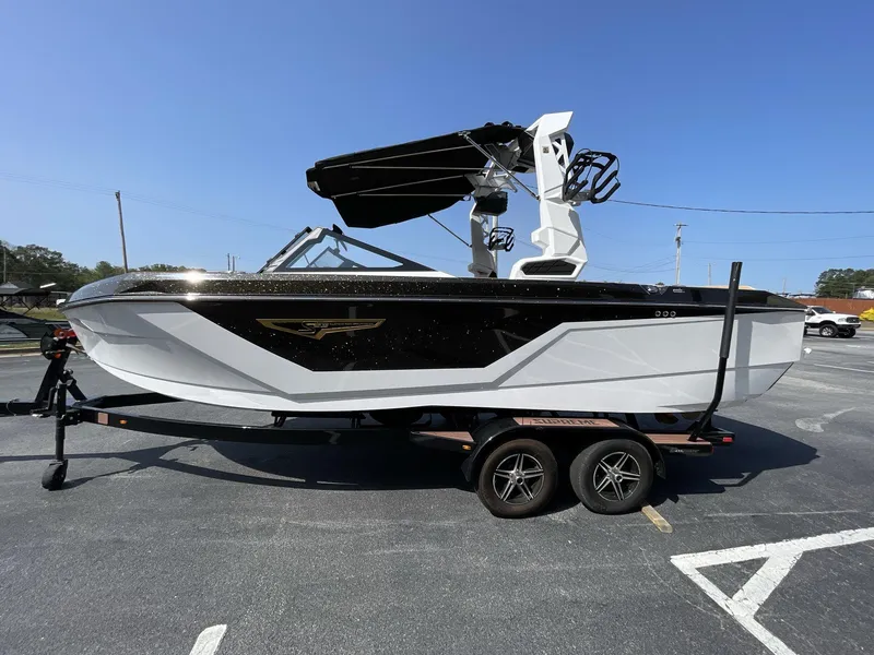 Slide: The Image of 2025 Nautique Super Air S S23 boat on trailer, black and white design. - 18