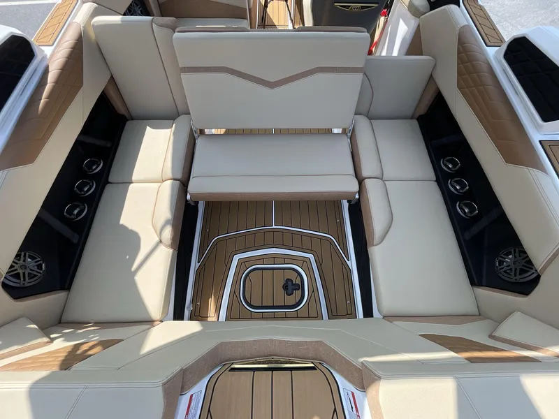 Slide: The Image of 2025 Nautique Super Air S S23 interior with beige seating and teak flooring. - 20