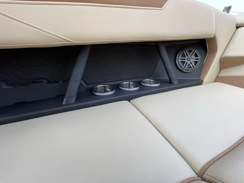 Slide: The Image of 2025 Nautique Super Air S S23 interior with cup holders and speaker. - 25
