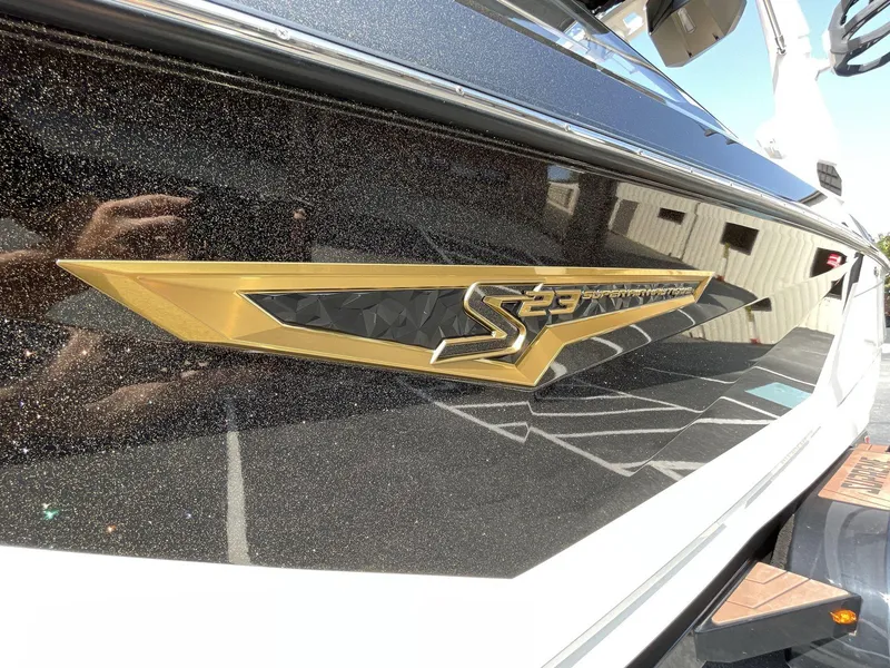 Slide: The Image of 2025 Nautique Super Air S S23 boat logo on sleek, glossy black surface. - 3