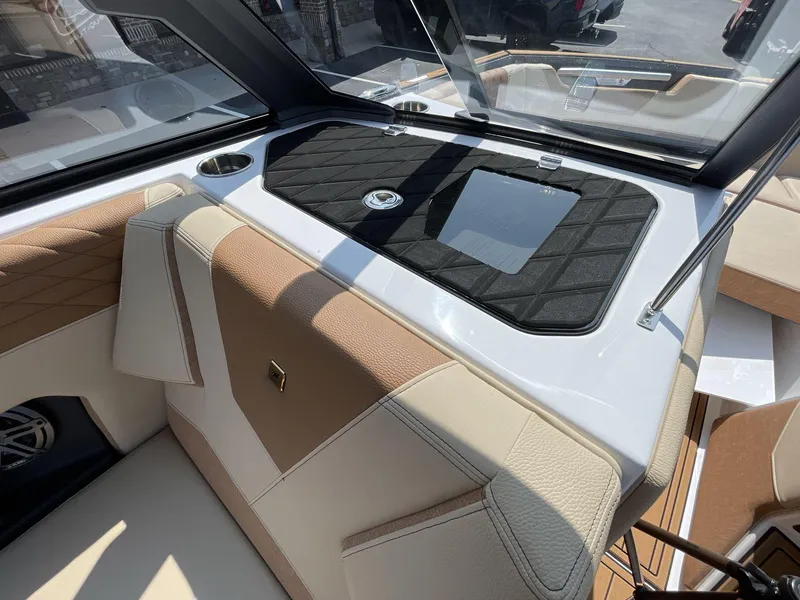 Slide: The Image of 2025 Nautique Super Air S S23 interior with tan and white upholstery, sleek dashboard design. - 9