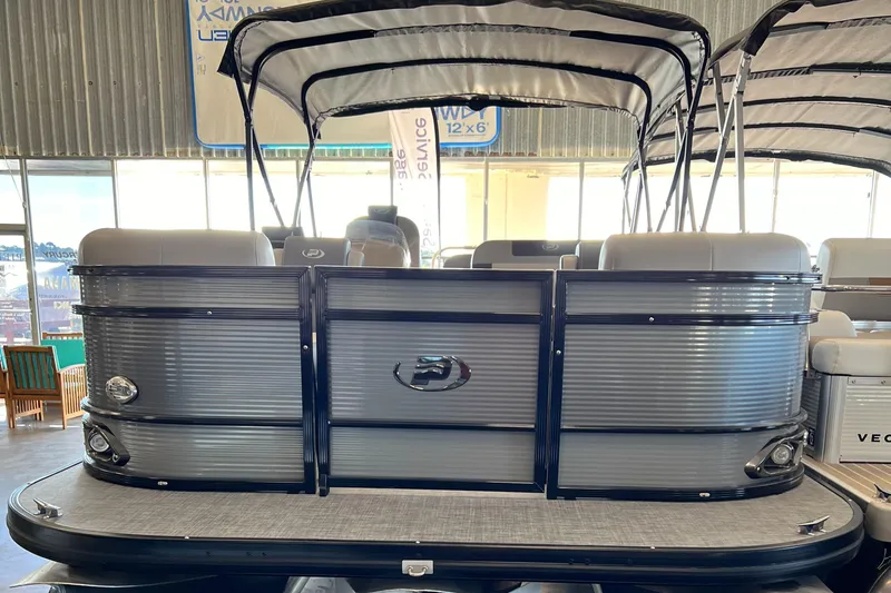 Slide: The Image of 2024 Princecraft Quorum 23 RL pontoon boat in showroom, featuring sleek design and canopy. - 4