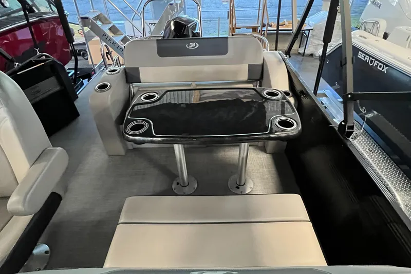 Slide: The Image of 2024 Princecraft Quorum 23 RL pontoon boat on trailer, parked outside service center. - 14