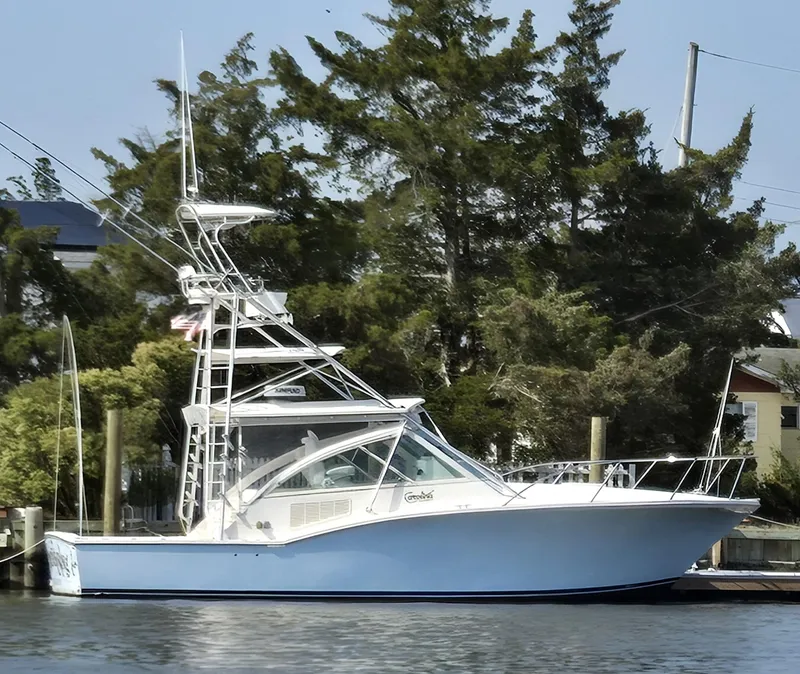The Image of 2007 Carolina Classic 35 boat docked near trees and buildings. - 0