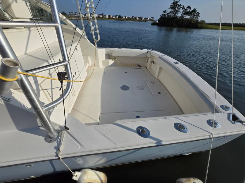 Slide: The Image of 2007 Carolina Classic 35 boat deck with fishing rod holders, docked on calm water. - 10