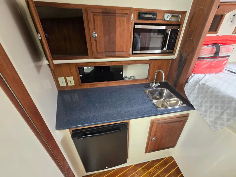 Slide: The Image of 2007 Carolina Classic 35 interior kitchen with sink, microwave, and wooden cabinetry. - 31