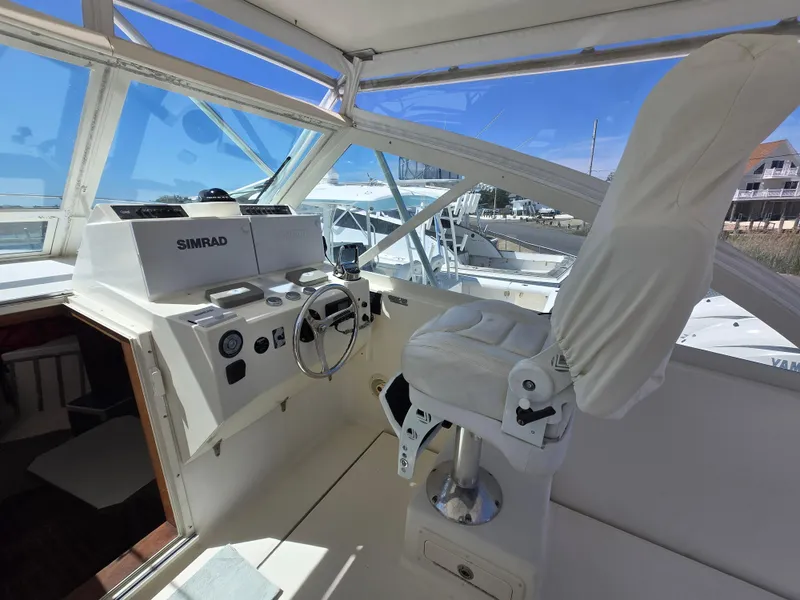 Slide: The Image of 2007 Carolina Classic 35 boat helm with Simrad navigation system and white captain's chair. - 35