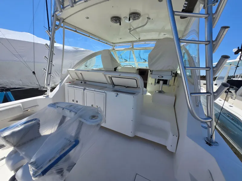 Slide: The Image of 2007 Carolina Classic 35 boat interior with helm, seating, and storage under clear blue sky. - 39
