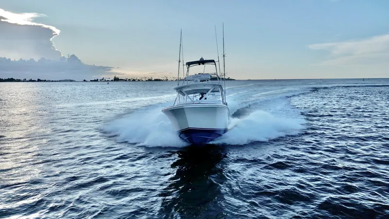 Slide: The Image of 2004 Predator 35 boat cruising on open water at sunset. - 21