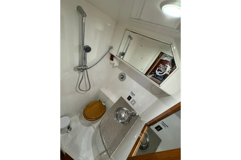 Slide: The Image of Compact bathroom in a 2004 Predator 35 boat with shower, sink, and toilet. - 33
