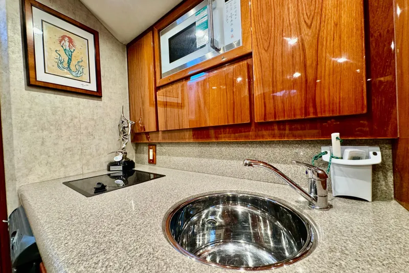Slide: The Image of Luxurious yacht kitchen with wood cabinets, sink, and microwave in a 2004 Predator 35. - 34