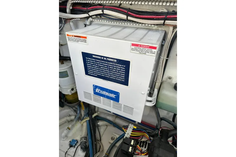 Slide: The Image of Cruisair unit in a 2004 Predator 35 boat engine room with wiring and warning labels. - 43
