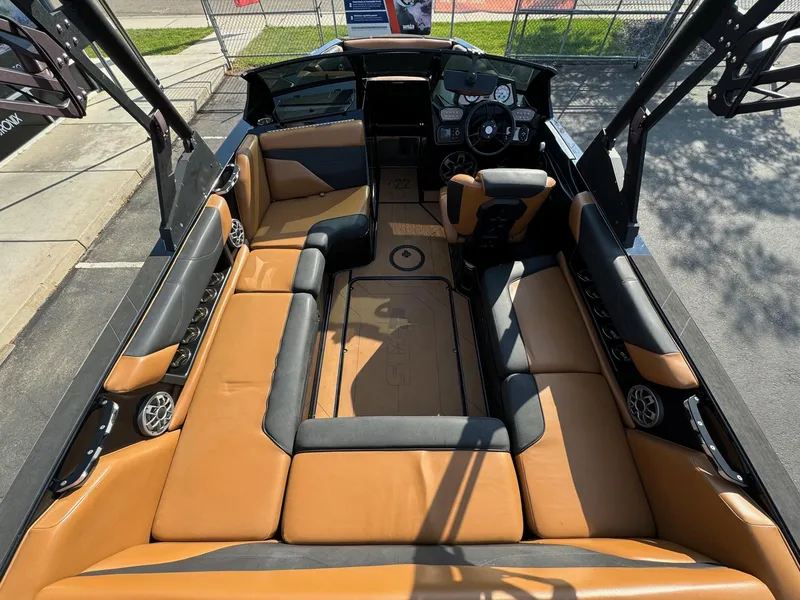 Slide: The Image of 2021 Axis A22 boat interior with tan and black seating, steering wheel, and speakers. - 11
