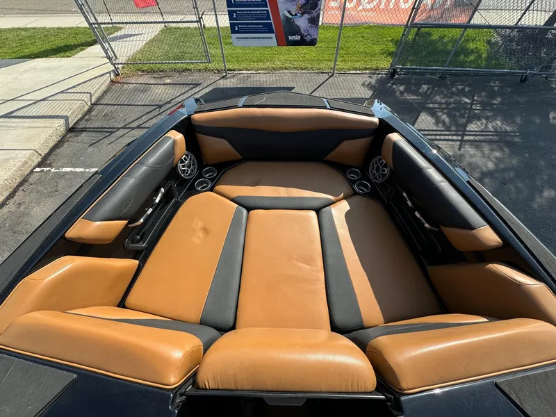 Slide: The Image of 2021 Axis A22 boat interior with tan and black seating, outdoor setting. - 13
