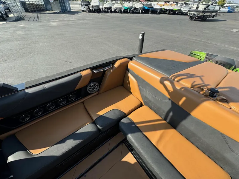 Slide: The Image of 2021 Axis A22 boat interior with tan and black seating, docked near other boats. - 16