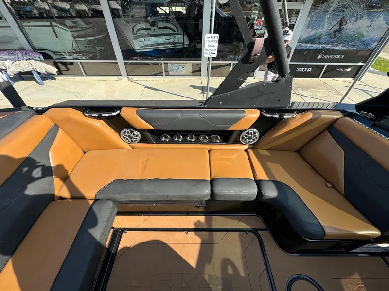 Slide: The Image of 2021 Axis A22 boat interior with tan and black seating, speakers, and cup holders. - 17