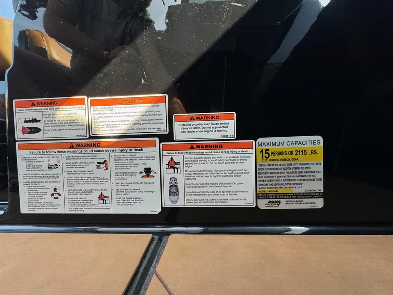 Slide: The Image of Warning labels and capacity information on a 2021 Axis A22 boat. - 27
